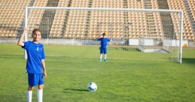 Two young boys playing soccer on a grassy field under clear skies. Perfect for sports themes.