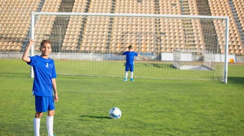 Two young boys playing soccer on a grassy field under clear skies. Perfect for sports themes.